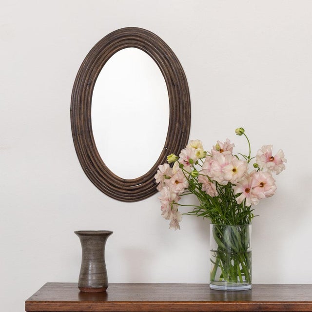 Beautiful vintage rattan mirror from France, 1960s. Oval stacked rattan frame encompassing mirror. Original mirror and...