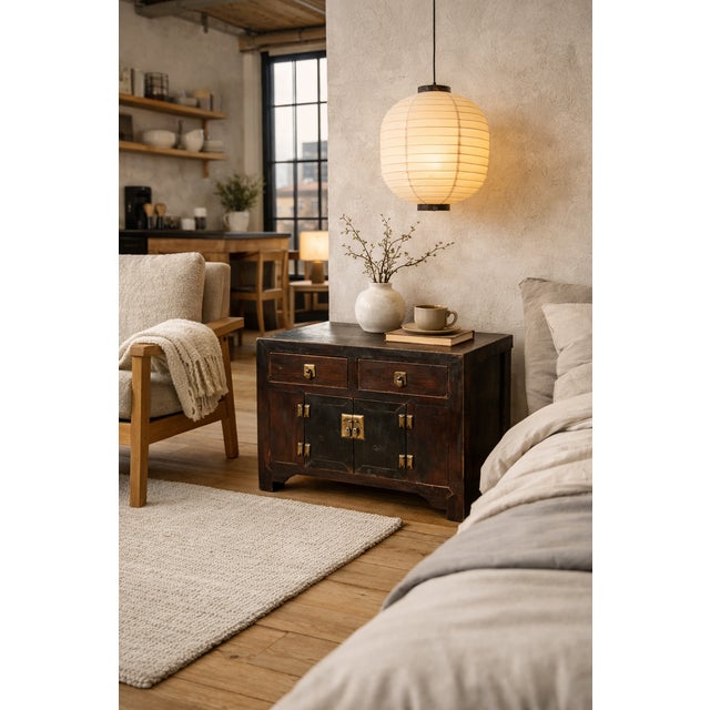 A beautifully aged antique Korean cabinet chest, crafted in dark stained Zeklova with traditional brass hardware and a...