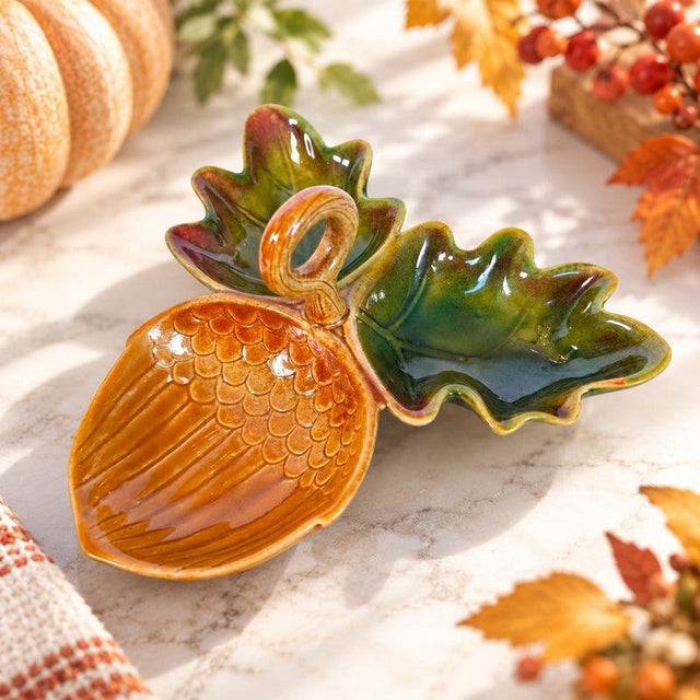 Charming sculptural ceramic serving dish featuring a dimensional acorn nestled between two beautifully molded oak leaves....