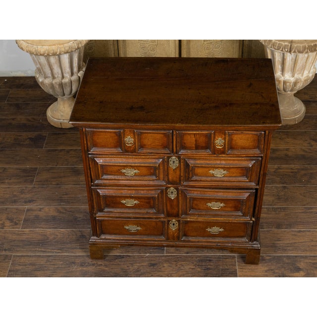 An English George III period oak geometric front chest from the early 19th century, with five drawers, brass Chippendale...
