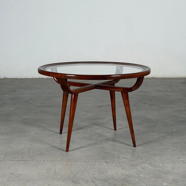 Elegant and sculptural round coffee table designed by Nicolay Diulgheroff in the 1950s, crafted in richly grained walnut...