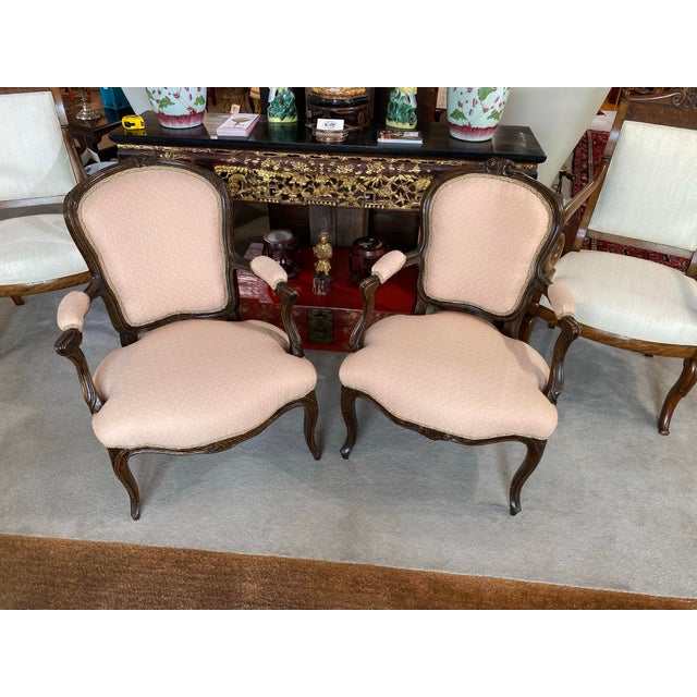 Great pair of Antique 18th Century Walnut French Louis XV-style Armchairs, known as Fauteuils, featuring carved dark wood...