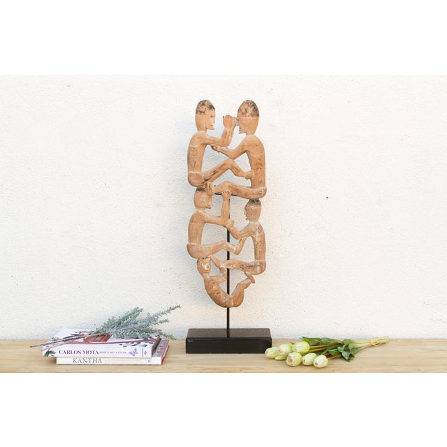 Figures like these don't stand alone, they hold each other up, literally. Carved from a single length of wood, this...