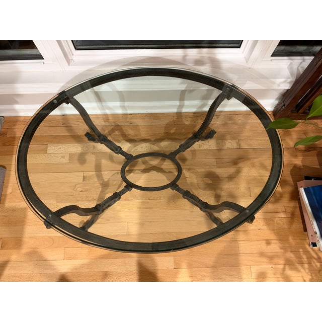 Gorgeous 1980s French wrought iron oval coffee table with beveled glass top. Features a hand forged iron base with classic...