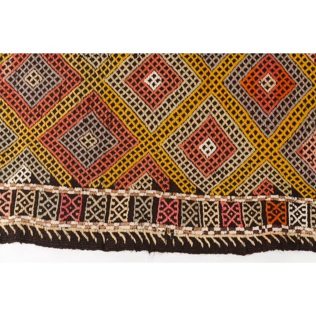 This is a vintage Turkish Oushak rug from the Mid 20th Century. The piece was hand-knotted.