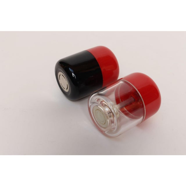 Vintage Postmodern Guzzini pepper and salt set (ca. 1970s, Italy). Pepper mill is black and red acrylic, and salt is...