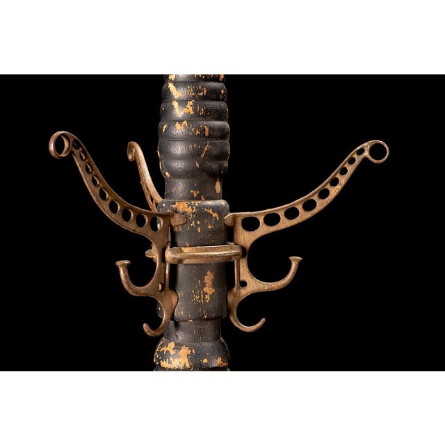 This early coat rack features cast iron hardware and has a handmade wooden tree. The coat rack separates into three parts....