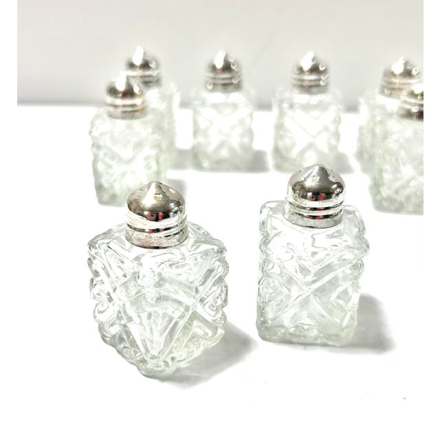 Vintage cut crystal salt and pepper shakers with silverplate tops, offered as a complete set of eight for four place...