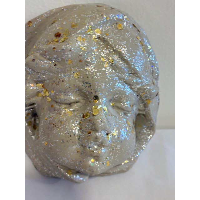 A charming vintage chalkware wall plaque featuring the serene face of a sleeping child. The sculpted relief is highlighted...