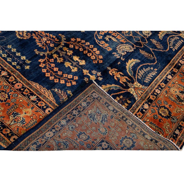 Beautiful antique Sarouk Farahan hand knotted wool rug with a navy-blue field. This Farahan rug has a rusted color frame...