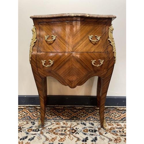 A beautifully crafted mid-20th century mahogany bombe chest, featuring an elegant marble top and ornate brass mounts...