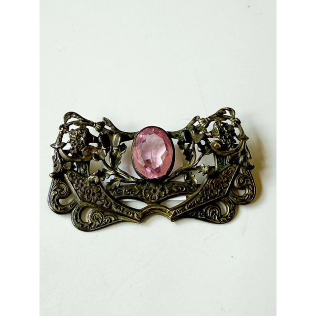 Antique Art Nouveau sash pin with pink center stone. Metal appears to be brass. Nice patina and lovely scrolling floral...