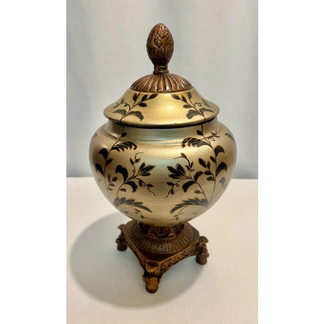 This Vintage Hollywood Regency Hand Painted and Gilt Footed Urn Trinket Box is a true work of art. Its exquisite design...