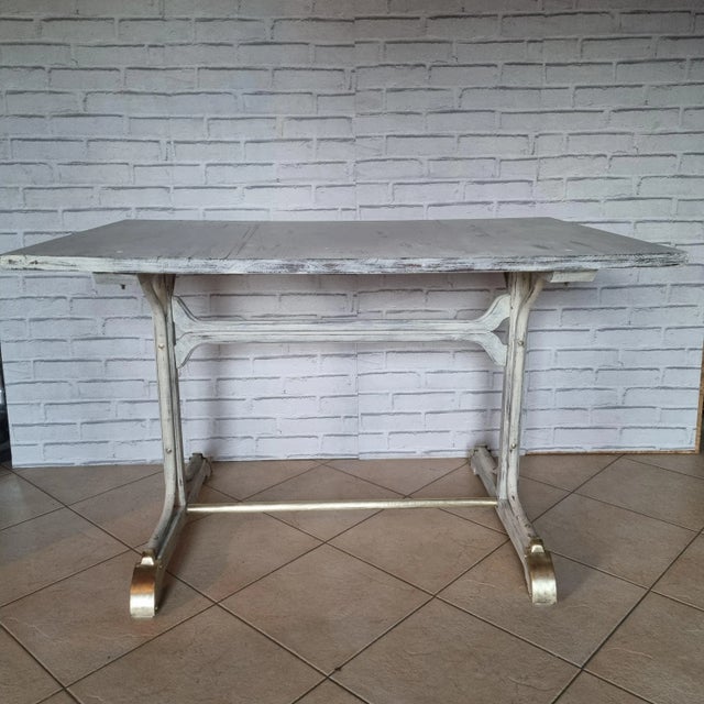 Bar patinated side table from the 1930s in beech and bentwood. The foot protectors and the cross bar are made of brass:...