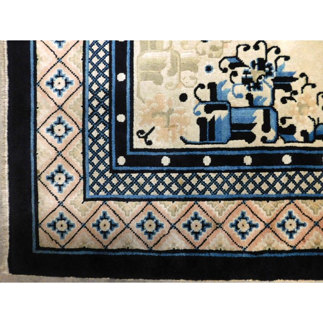 Ivory field with geometric central medallion surrounded by scattered floral bundles. Main border decorated with geometric...