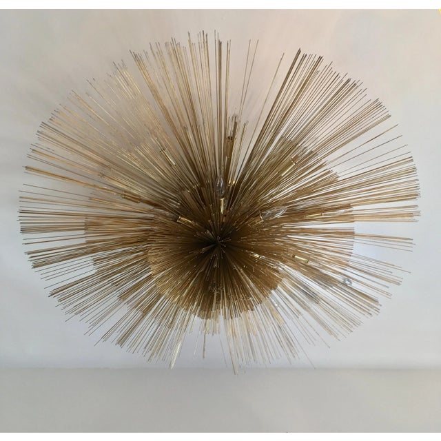 A wonderful thirteen-light brass three-tier flush mounted light sculpture composed of golden aged brass and enameled steel...