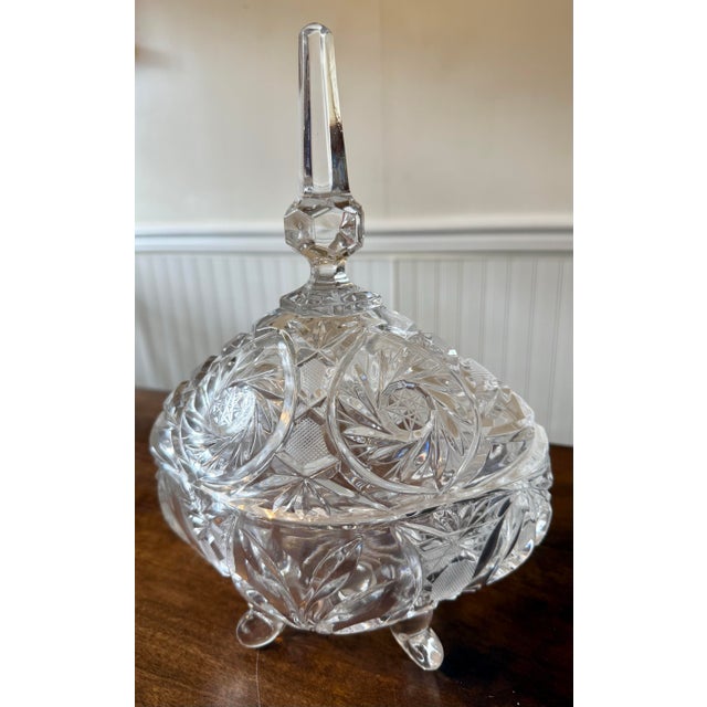 This is a beautiful, footed lead crystal candy dish, featuring a distinct lid topped with a tall obelisk-shaped finial....