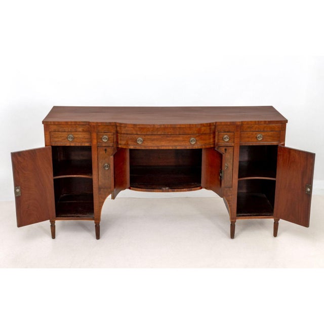 American Federal Figured Mahogany Sideboard, the bowfront top with single pull-out surface, central frieze drawer above...