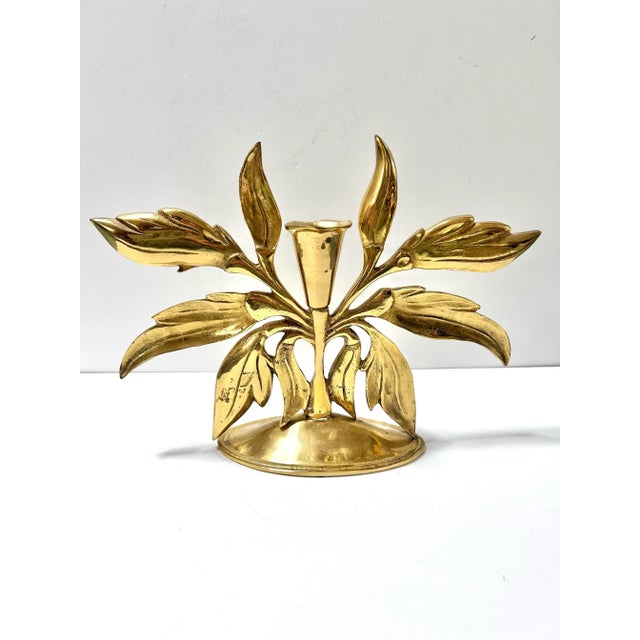 A dramatic vintage Hollywood Regency brass candlestick designed as blooming leaves radiating from a central stem. This...