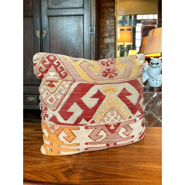 This small pillow is custom-made from a fragment of an antique, handwoven Kilim rug. The design features geometric motifs...