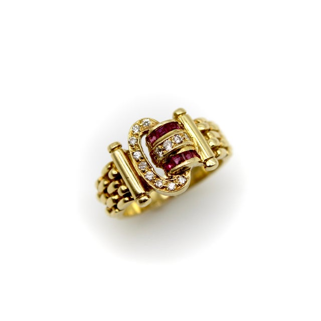 This is an 18k gold finely crafted buckle ring with rubies and diamonds. The ring has classic 1980’s design work that...