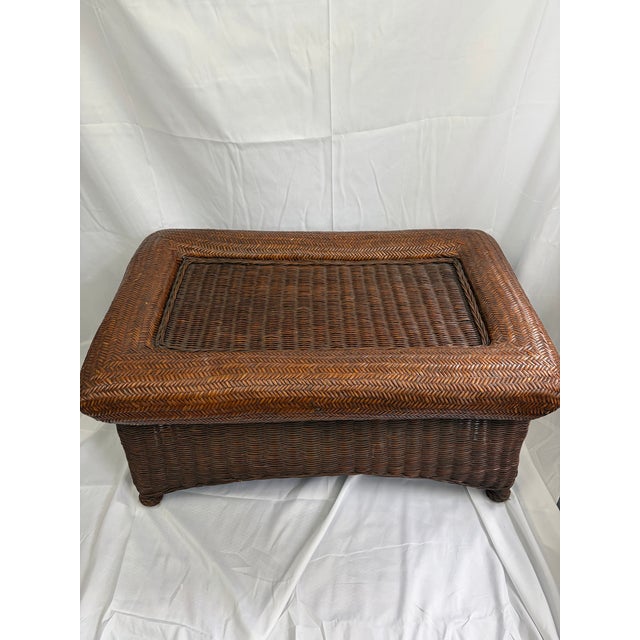 A late 20th century rectangular rattan coffee table finished in a warm walnut tone. The solid woven top and clean...