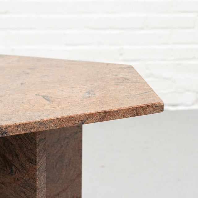 Geometric granite coffee table from the 1970s, entirely made from warm reddish-brown granite with a lively natural...