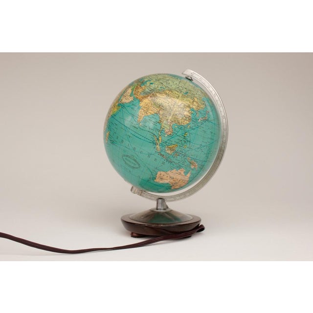 Small illuminated Columbus globe, W. Kaden, made in the 1950s. Paper print on a glass globe. Base made of wood and metal....