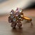 This charming 1980s floral cluster ring features a joyful spray of pink and clear stones arranged in a sakura-inspired...