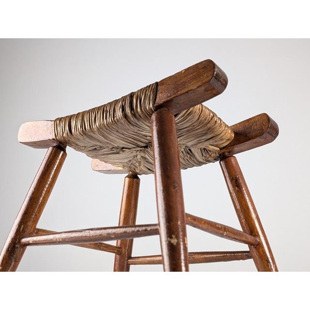 Vintage wooden and rush stool made in Spain during the 1940s. The frame is made of solid turned wood, featuring tapered...