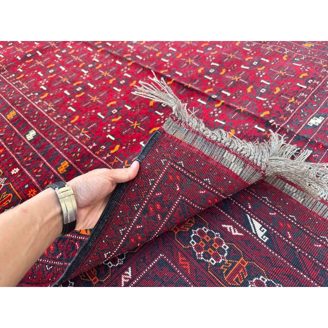 This finely woven Afghan Mauri rug features a densely packed lattice of small geometric diamonds and stylized motifs in...