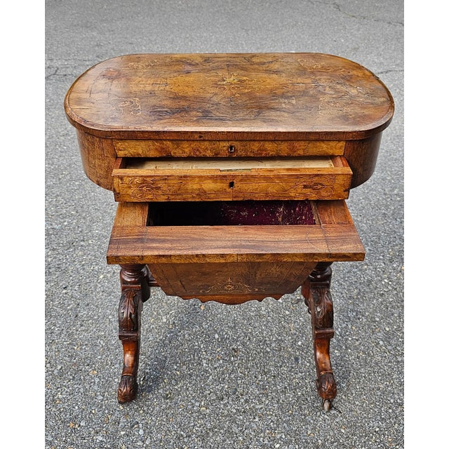 A 19th Century Victorian Walnut and Marquetry Burl sewing table with plenty 9f storage and on Wheels. Measures 24.25" in...