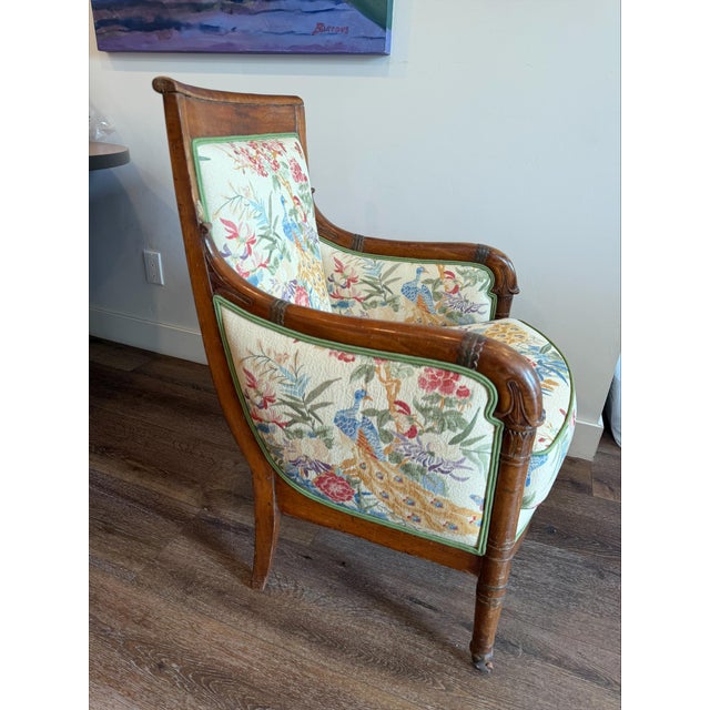 Mid 1800s Vintage French Louis XVI armchair features a carved hardwood frame with scrolling arms original wooden casters,...