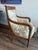 Mid 1800s Vintage French Louis XVI armchair features a carved hardwood frame with scrolling arms original wooden casters,...