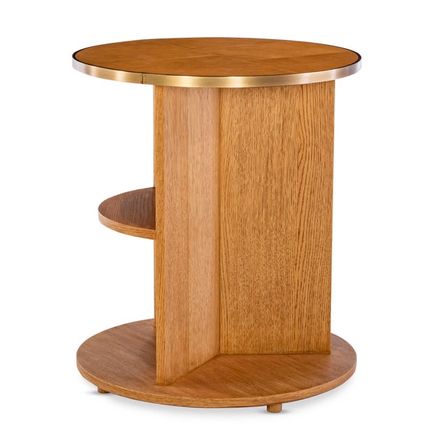 This round side table pairs warm, modern materials with sculptural balance. The caramel leather–wrapped top is framed in...