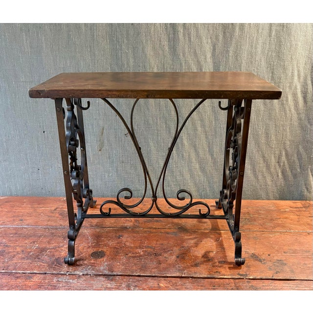 Charming small table or bench with decorative base and wood top. Appears to have been upholstered on the top at one point...