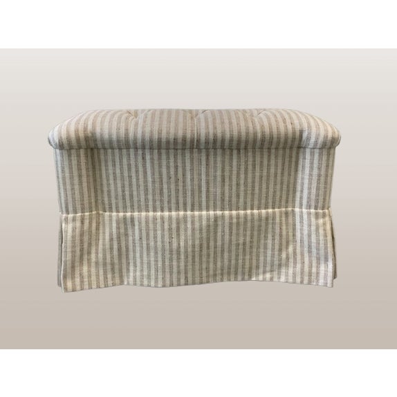 Newly upholstered ottoman. Neutral stripe fabric. Tufted top with skirt.