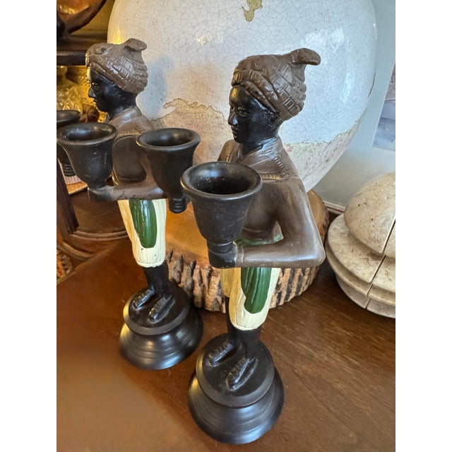 A striking pair of vintage figural candleholders crafted in heavy cast metal and hand-painted in rich, traditional colors....