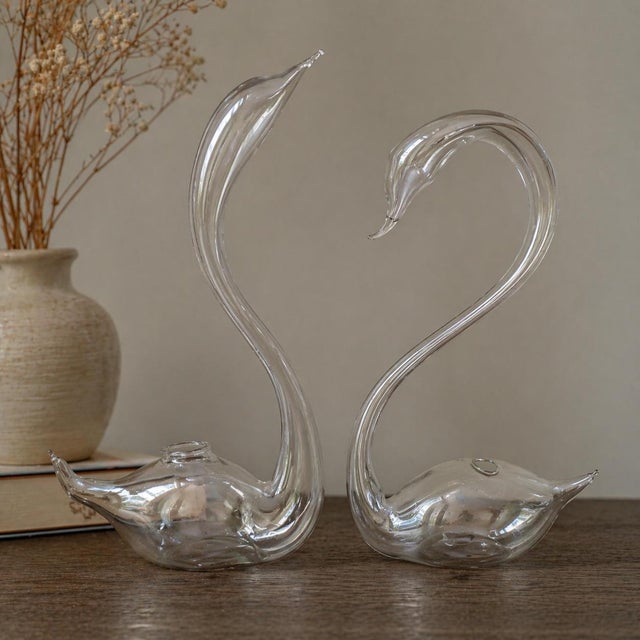 Elevate your space with this exquisite pair of vintage glass swan bud vases, crafted in delicate clear blown glass with...