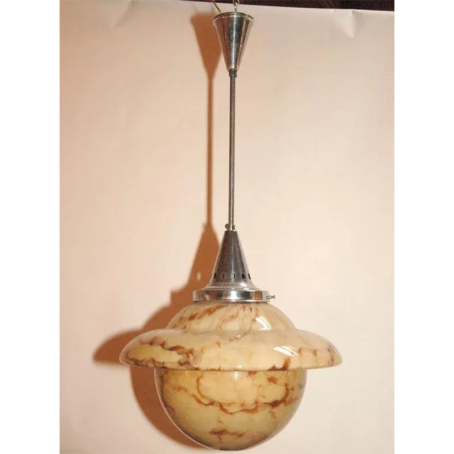 This Mid Century Modern Italian glass hanging lighting fixture has a wonderfully coloring along with the chrome elements....