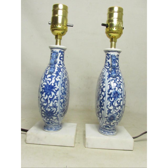 Pair of Chinese porcelain blue and white vase lamps, c.1940’s These small scale lamps have a moon-flask shaped flat body...