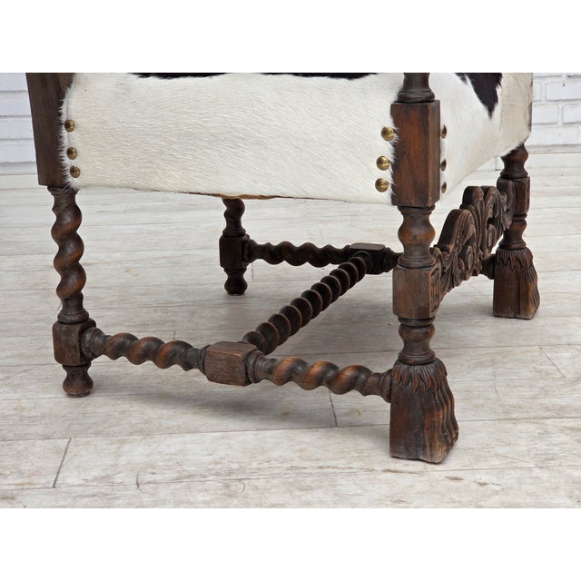 1950s, Danish highback armchair. Reupholstered by craftsman in genuine cowhide. Carved oak wood, brass springs in the...