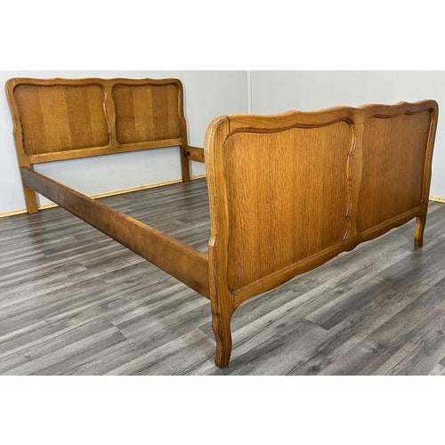 A charming Vintage French Louis style single bed frame in oak, featuring softly shaped panels and elegant curves, offered...