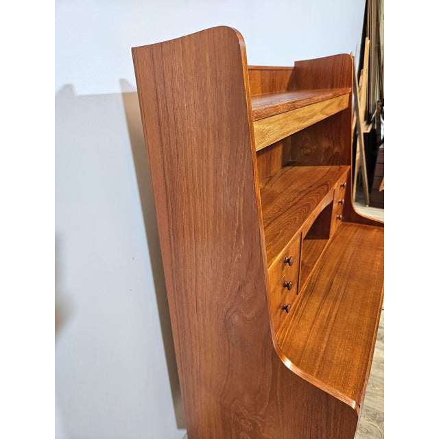 Beautiful Danish secretary's desk from the 1960s. The structure is covered with teak veneer. The legs are made of solid...