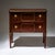 Neoclassical chest of drawers with two drawers, raised on block-mounted tapered square legs. The piece is veneered in...