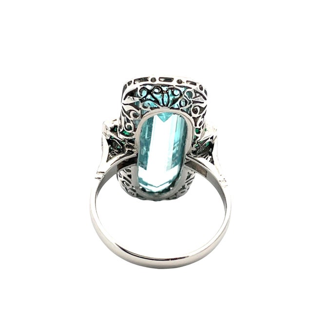 Elegant reproduction platinum ring featuring a striking emerald-cut aquamarine weighing approximately 9.61 carats, framed...