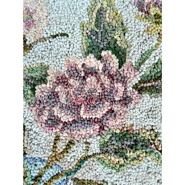 An American hooked rug, circa 1930s, depicting an airy arrangement of pink roses and flowering branches in a blue and...