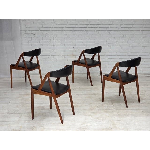 1960s, Danish design by Kai Kristensen. Set of 4 armchairs, model 31. Original black leather with patin. Solid teak wood...