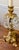 This pair of vintage candle holders are characterized by their elaborate gold colored metalwork and dangling crystal...