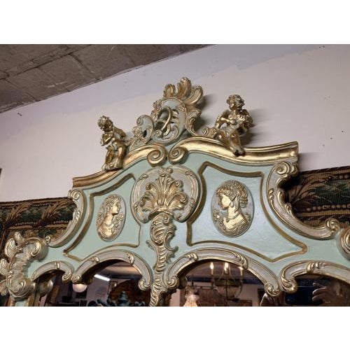 An exquisite and truly imposing French-style mirror, crafted with a richly ornate parcel-gilt and painted frame that...